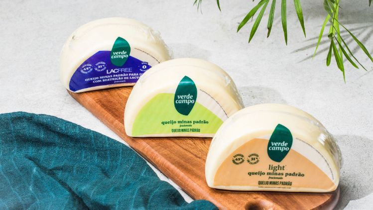 Queijos Minas padrão Verde Campo (tradicional, light e lacfree) dispostos sobre tábua de madeira em cenário claro e minimalista.