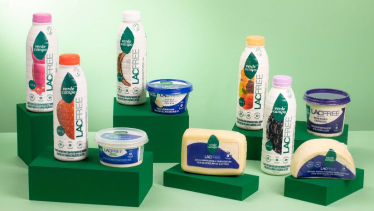 Linha completa de produtos lacfree Verde Campo organizada sobre blocos verdes em cenário monocromático.