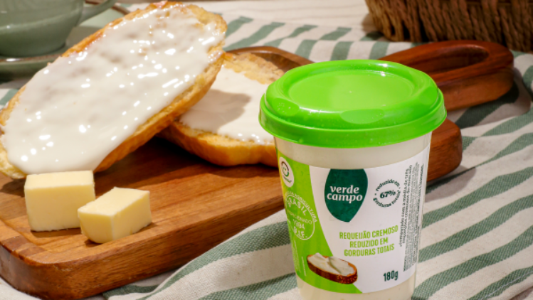 Requeijão cremoso Verde Campo em pote, servido com pão, manteiga e café em mesa de café da manhã.