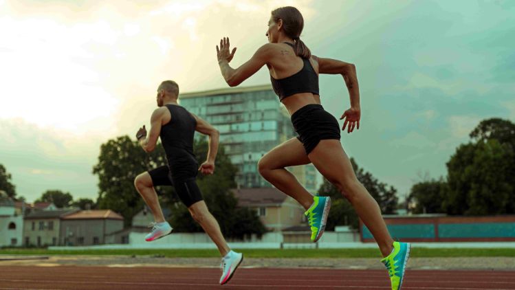 Duas pessoas correndo em pista ao ar livre durante treino de corrida