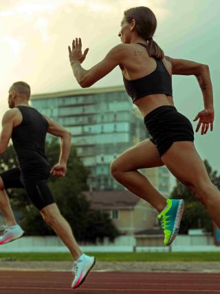 Duas pessoas correndo em pista ao ar livre durante treino de corrida